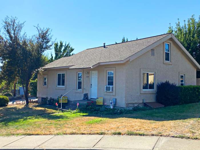 A house with a red door and a white car parked in front with the text "Call Jordan 479-857-7207".