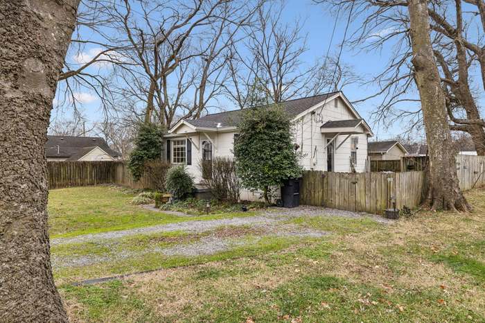 A house with a red door and a white car parked in front with the text "Call Jordan 479-857-7207".