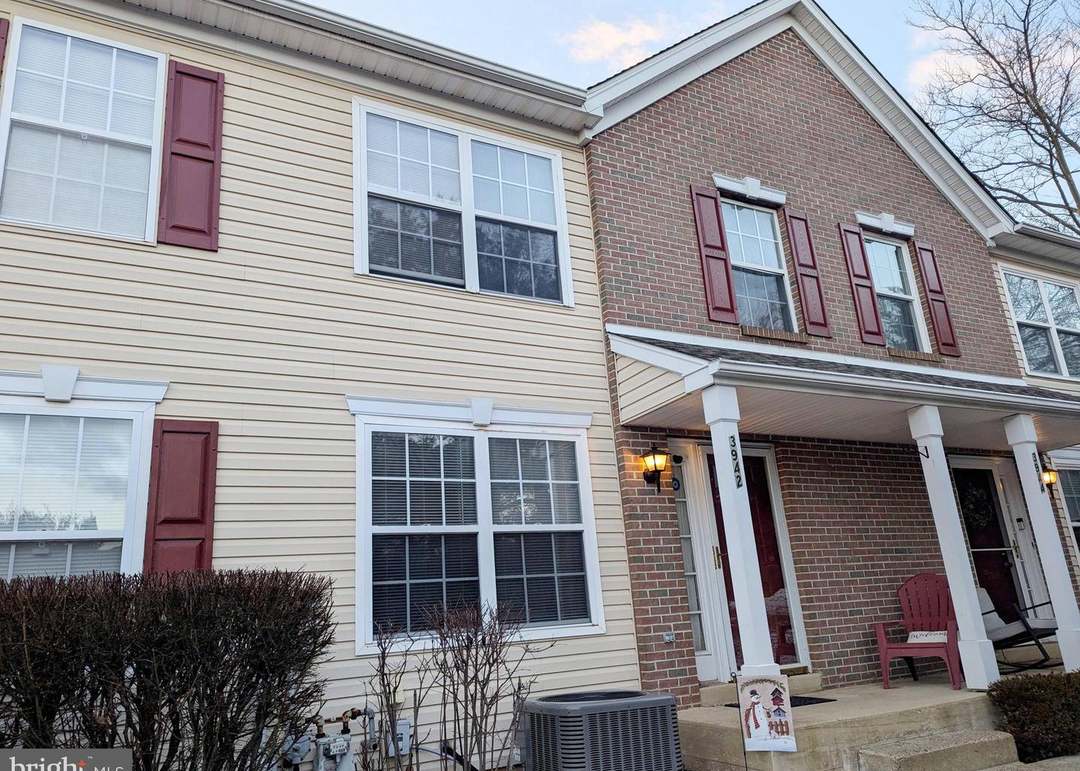 A house with a red door and a white car parked in front with the text "Call Jordan 479-857-7207".